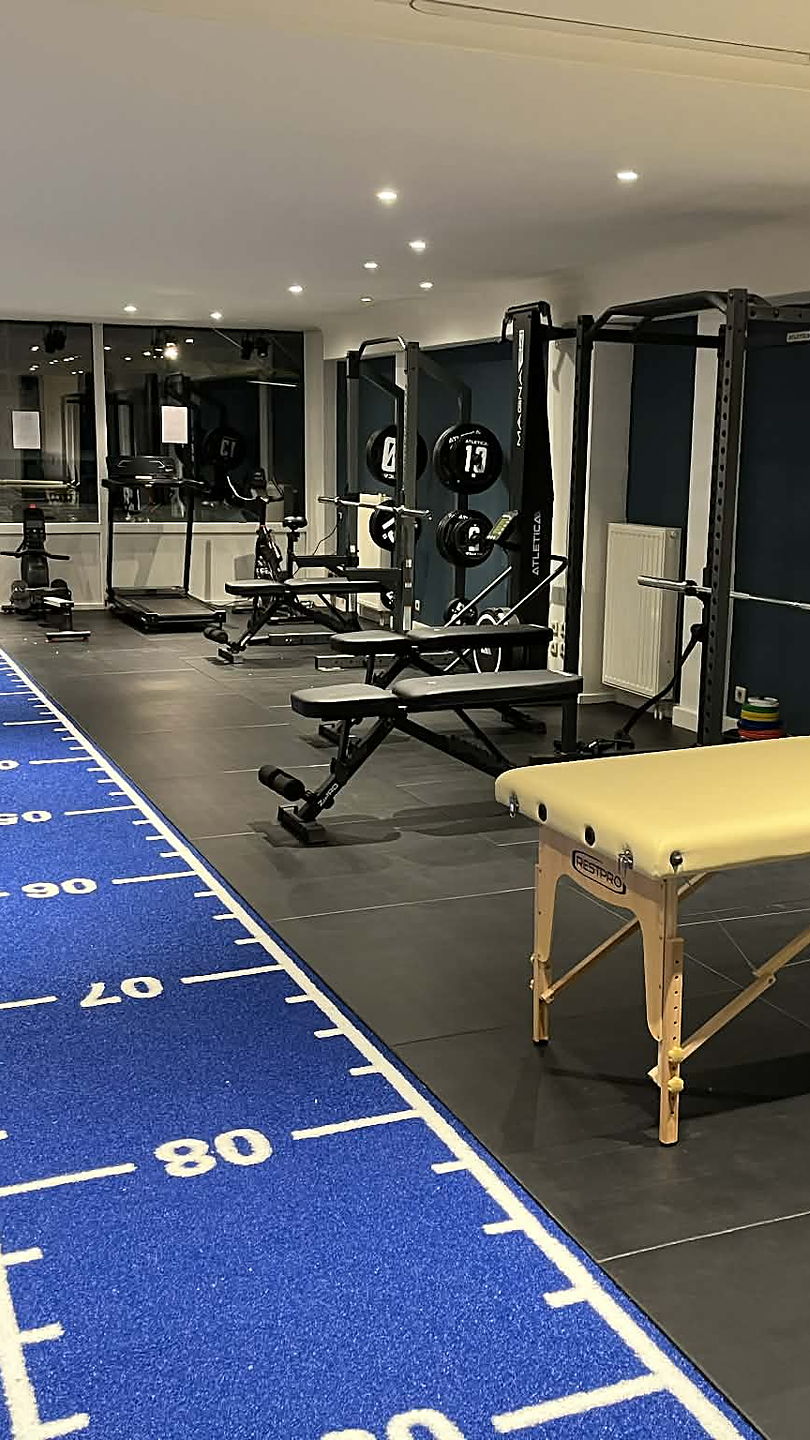 La salle du VLSport Center à Wavre : piste de sprint bleue, racks et bancs de musculation